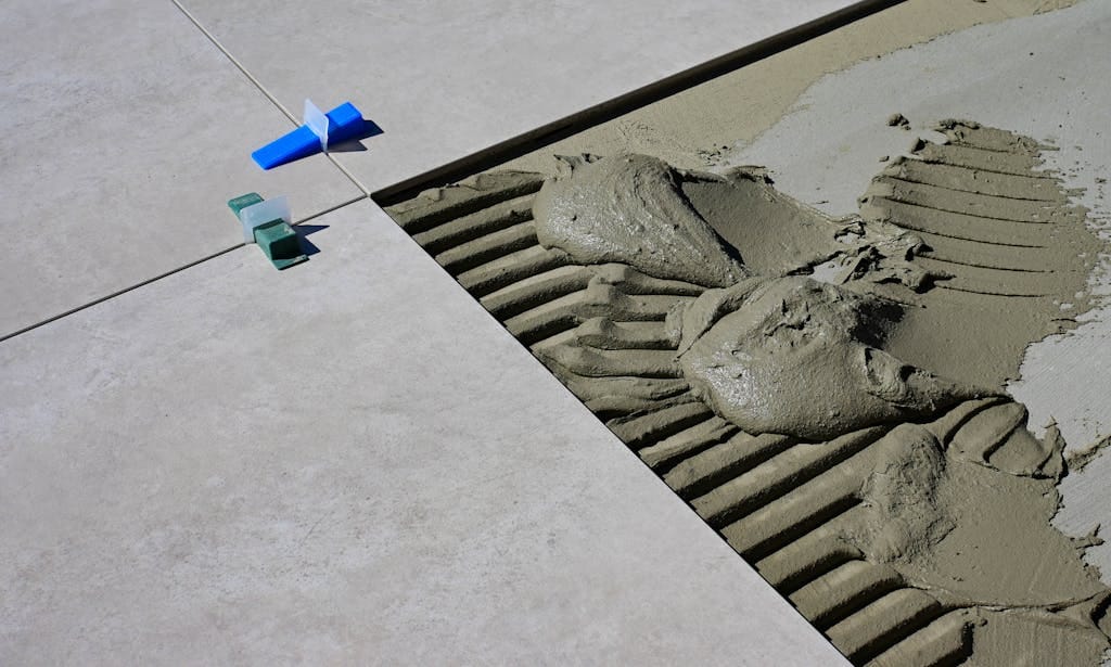 Close-up of the best cement for house construction during floor tile installation.